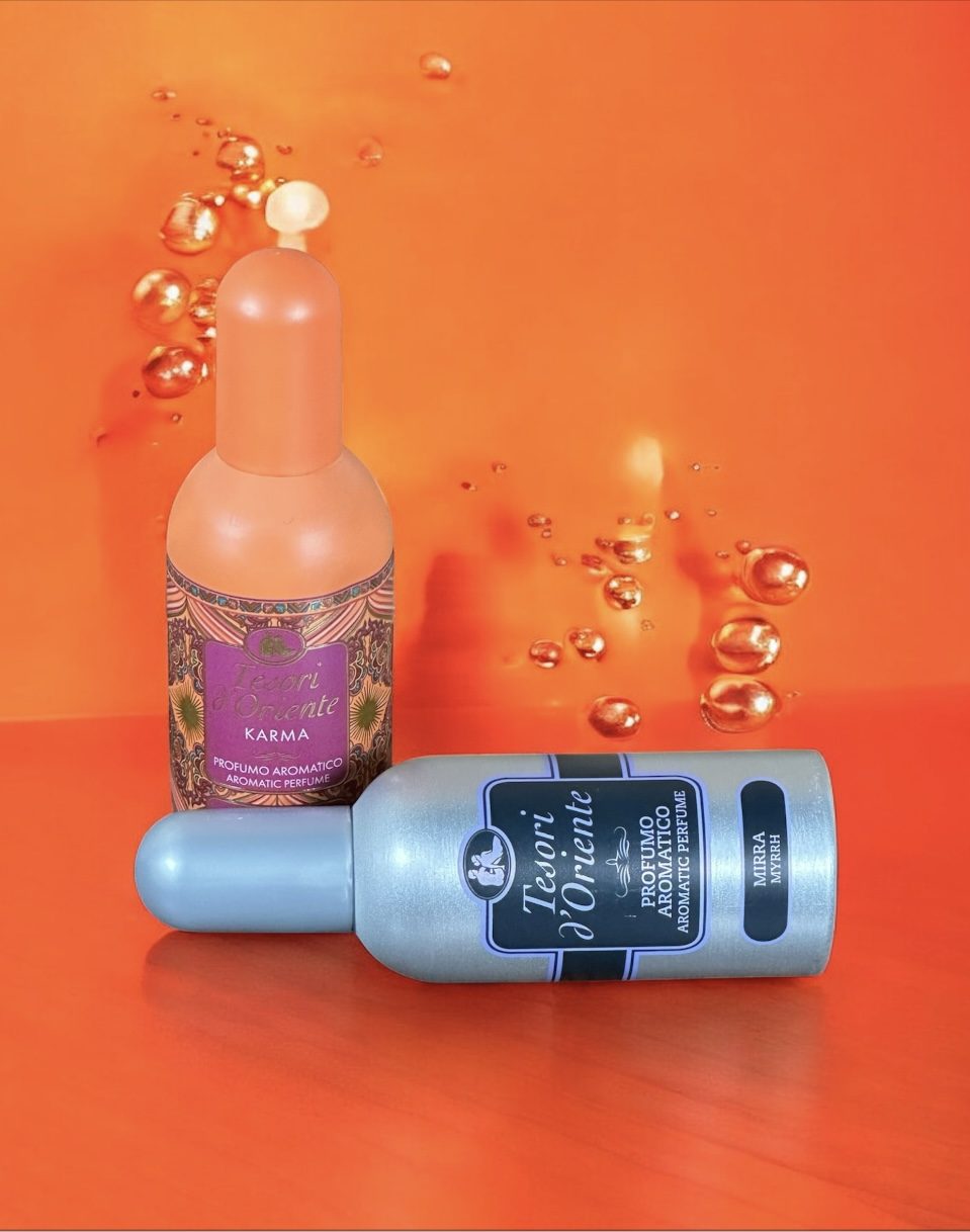 Two cosmetic serum bottles on an orange background with decorative bubbles.